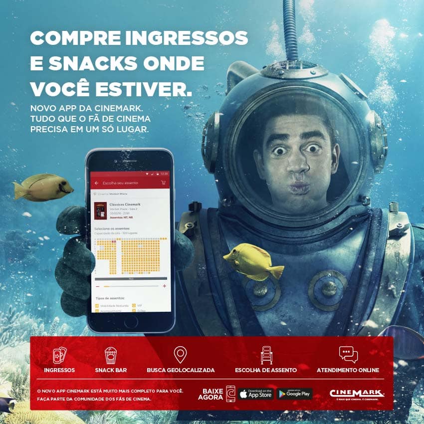 Marcelo Adnet no fundo do mar com um celular na mão divulgando novo app da Rede Cinemark para compra de ingressos, combos e vantagens exclusivas